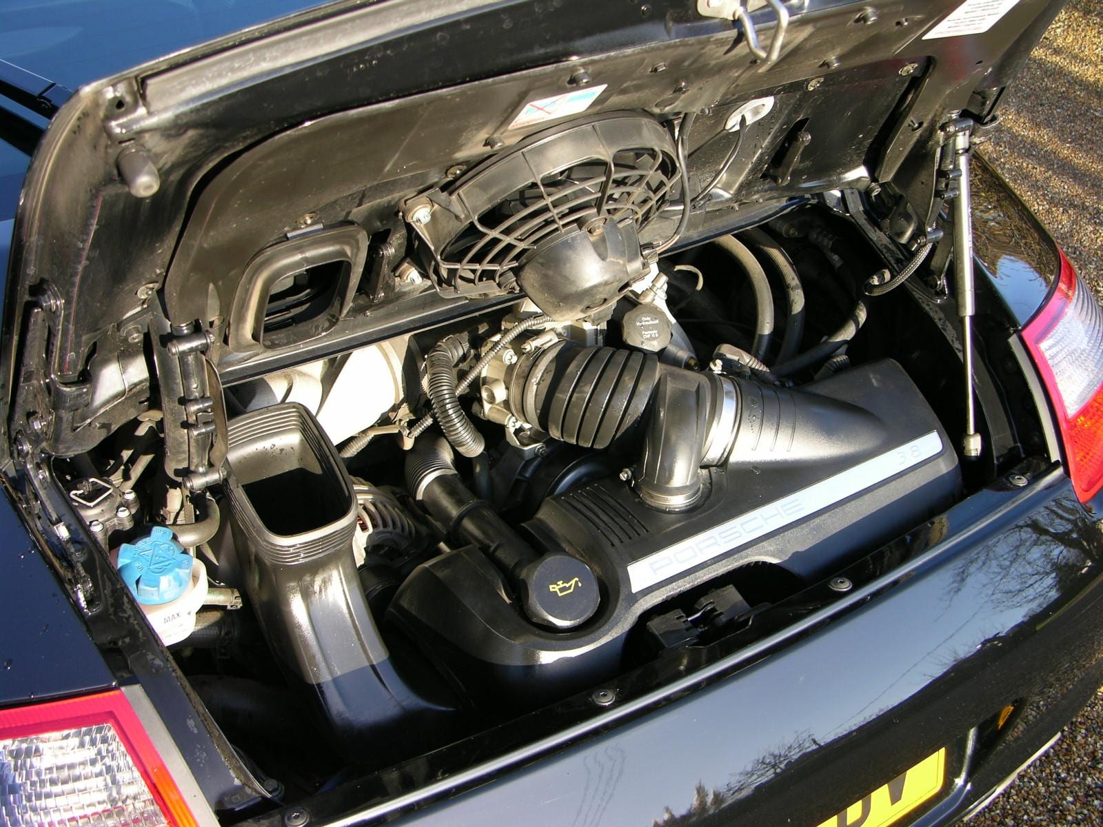 Engine bay of a black Porsche 911 (997) Carrera S with the engine lid open